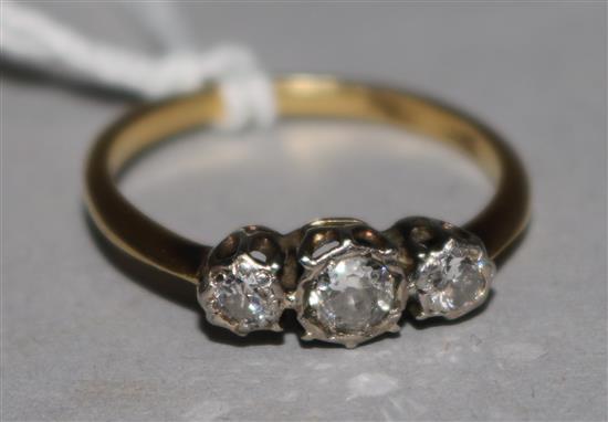 An 18ct gold and platinum, three stone diamond ring, size P/Q